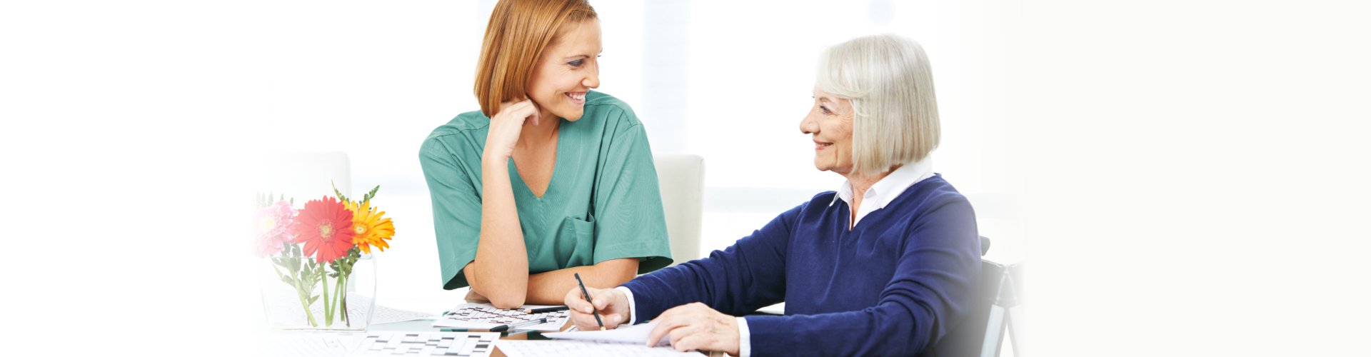a happy caregiver talking to a senior woman